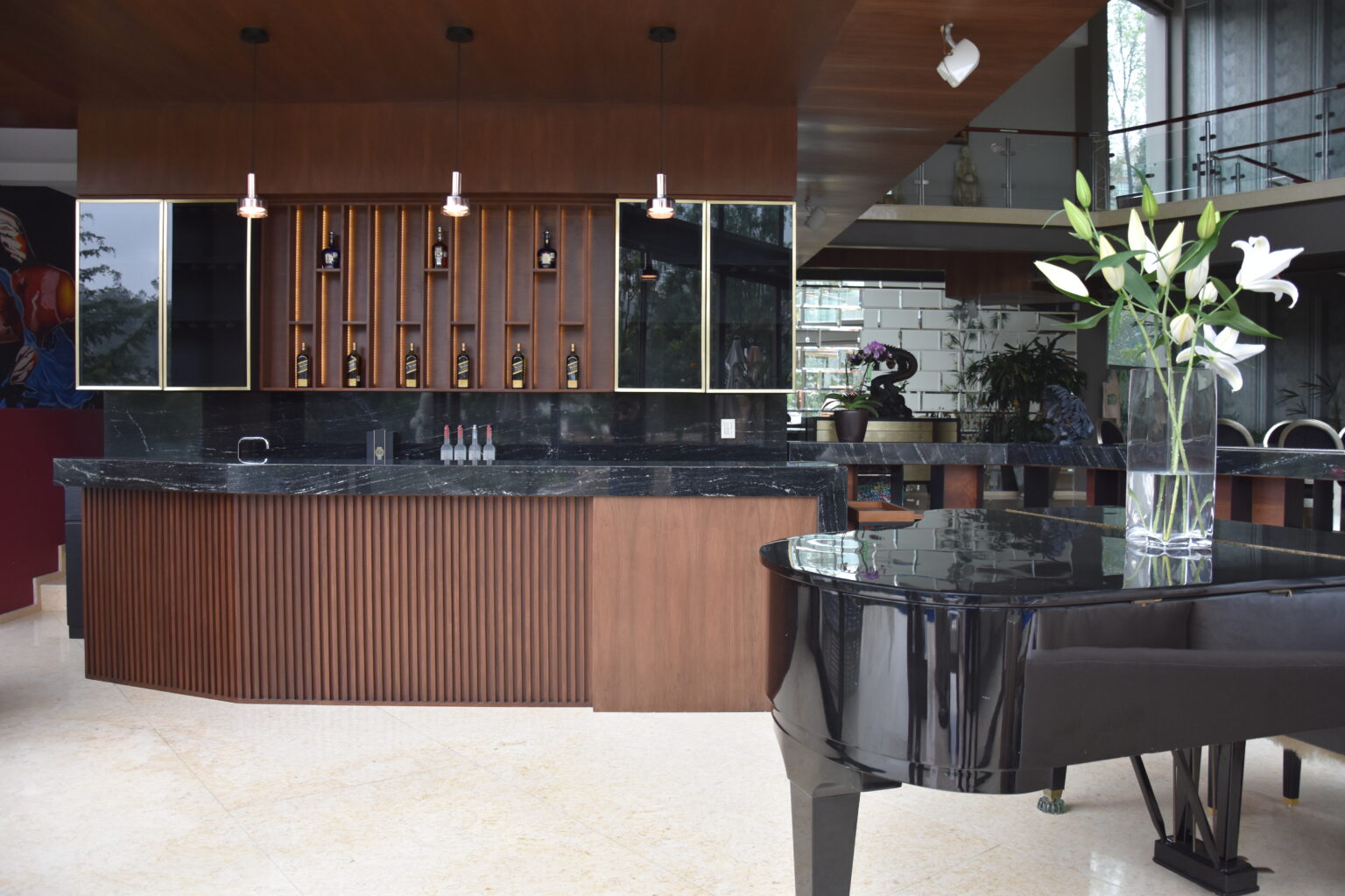 Bar residencial de Bosque Real 49 con carpintería iluminada, mármol negro y piano