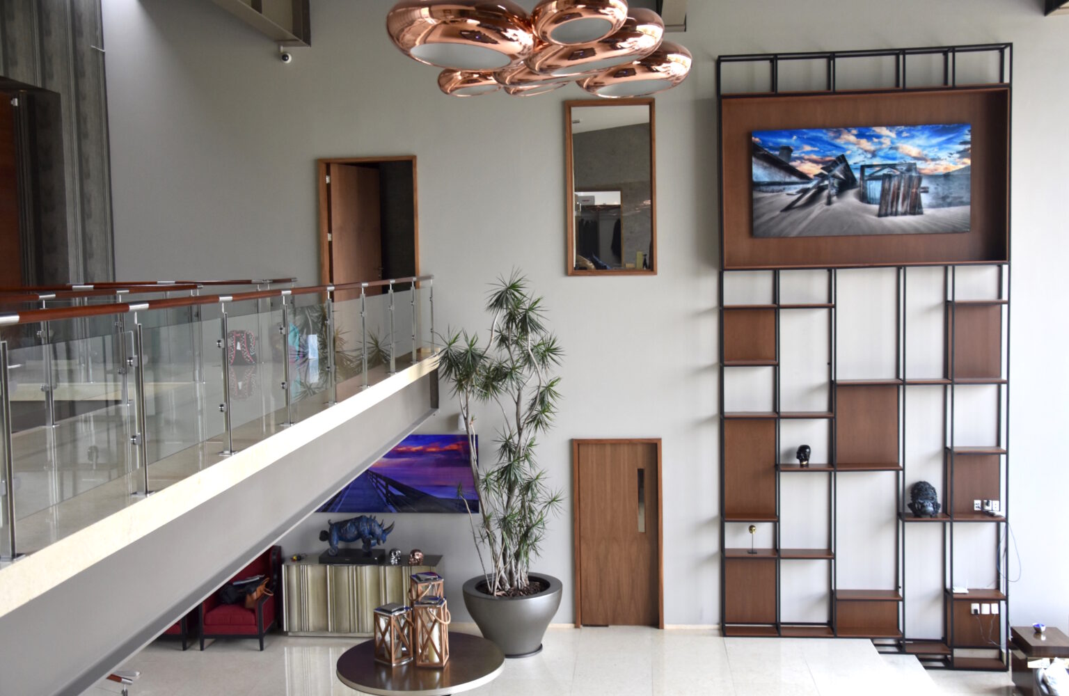 Mueble de televisión de madera y metal en la sala de doble altura de Bosque Real 49