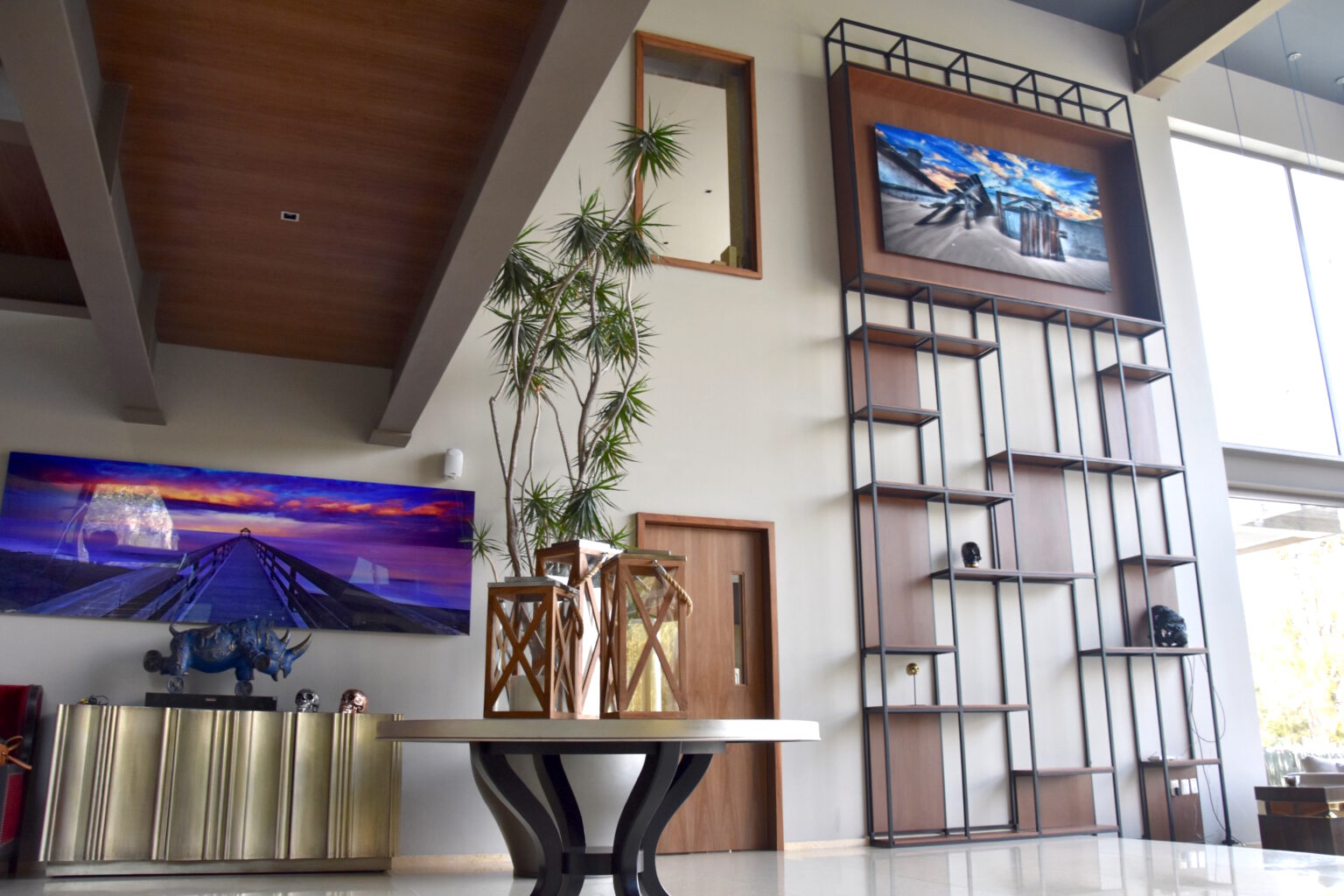 Sala de doble altura de Bosque Real 49 con mueble multimedia y consola metálica