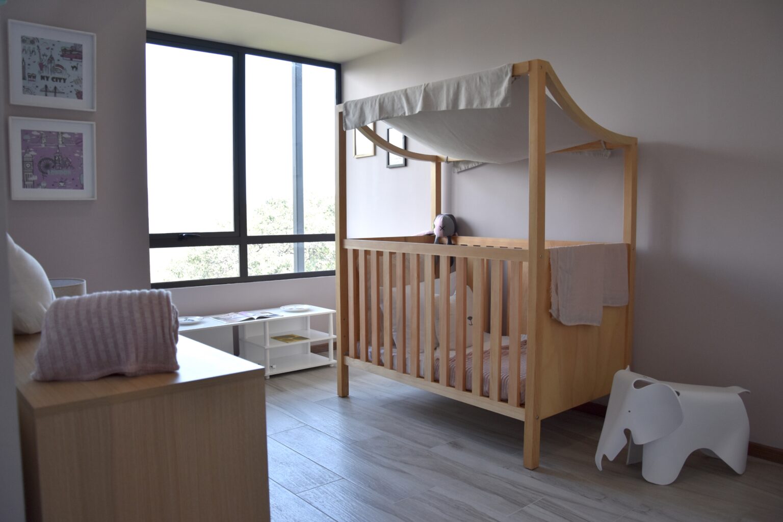 Cuna de madera con dosel y mobiliario infantil en Real de Monteza