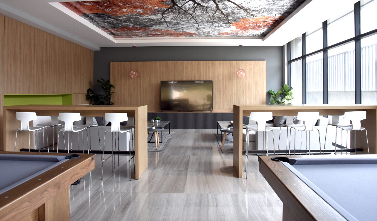 Salón de juegos con mesas de billar, barras altas y sala de televisión en Borgó