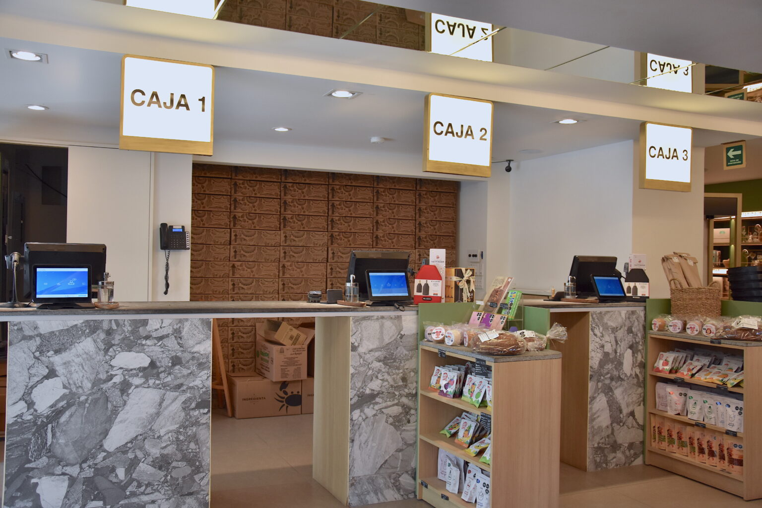 Tres cajas con frentes de mármol y señalización iluminada en Ingredienta Pedregal