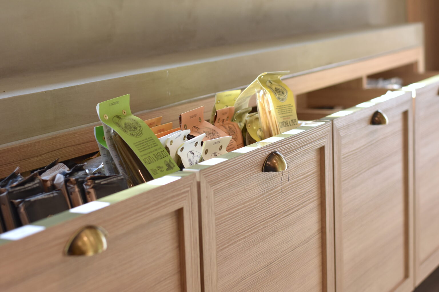 Mueble de madera con cajones para producto gourmet en Ingredienta Prado Norte