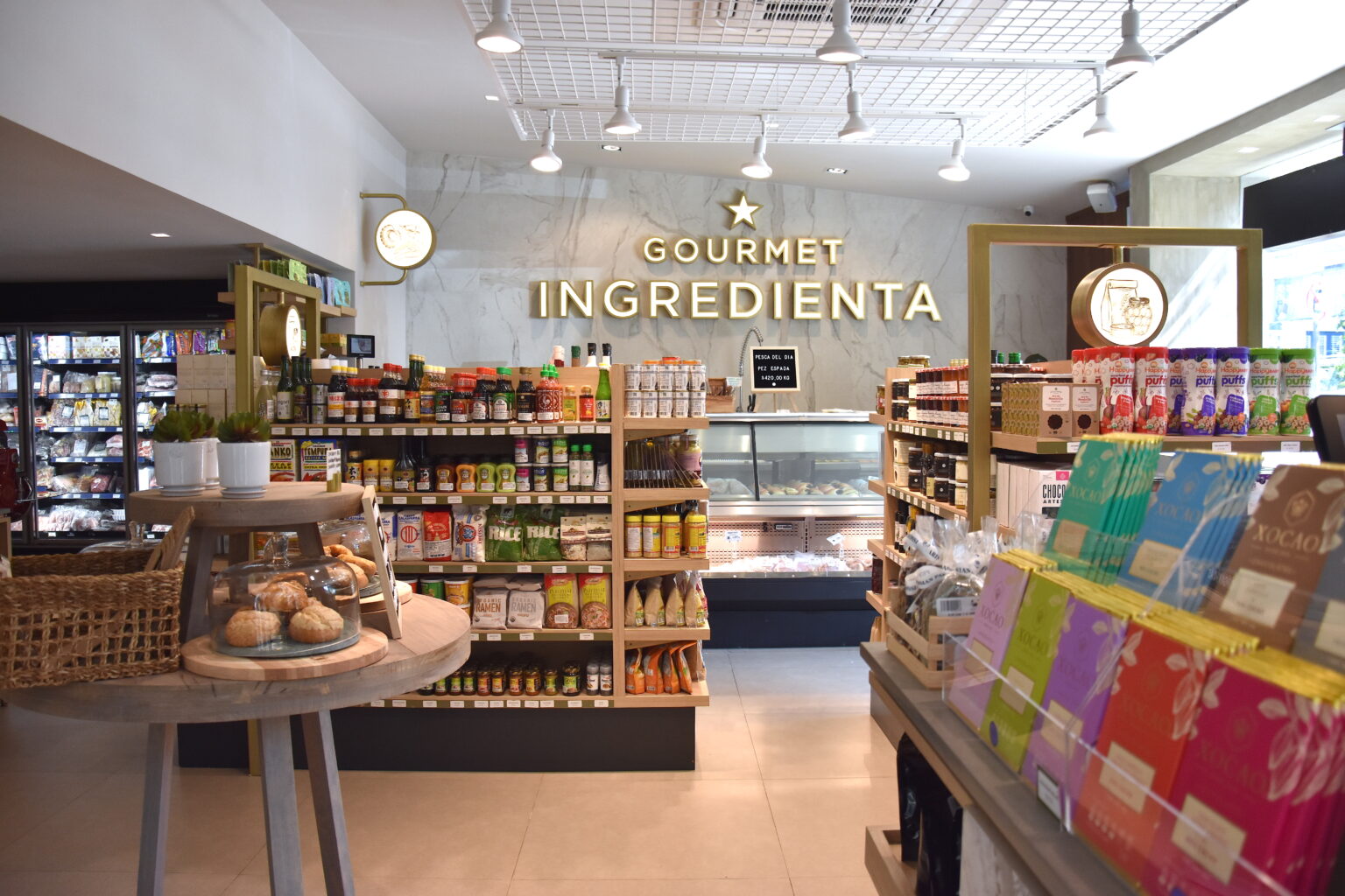 Interior de Ingredienta Prado Norte con estantes de productos y rótulo Gourmet Ingredienta