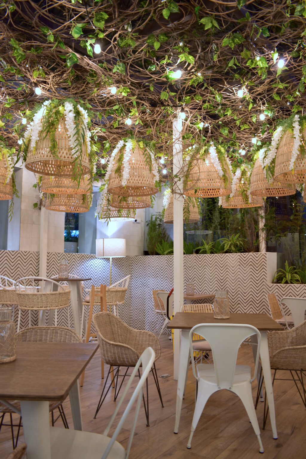 Terraza nocturna de Ingredienta Prado Norte con techo vegetal y lámparas de mimbre