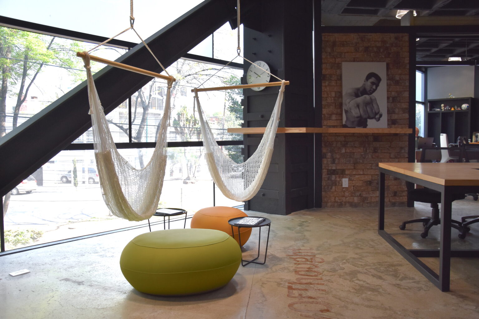 Zona de descanso con hamacas y pufs junto a ventanal en las oficinas M&C Saatchi