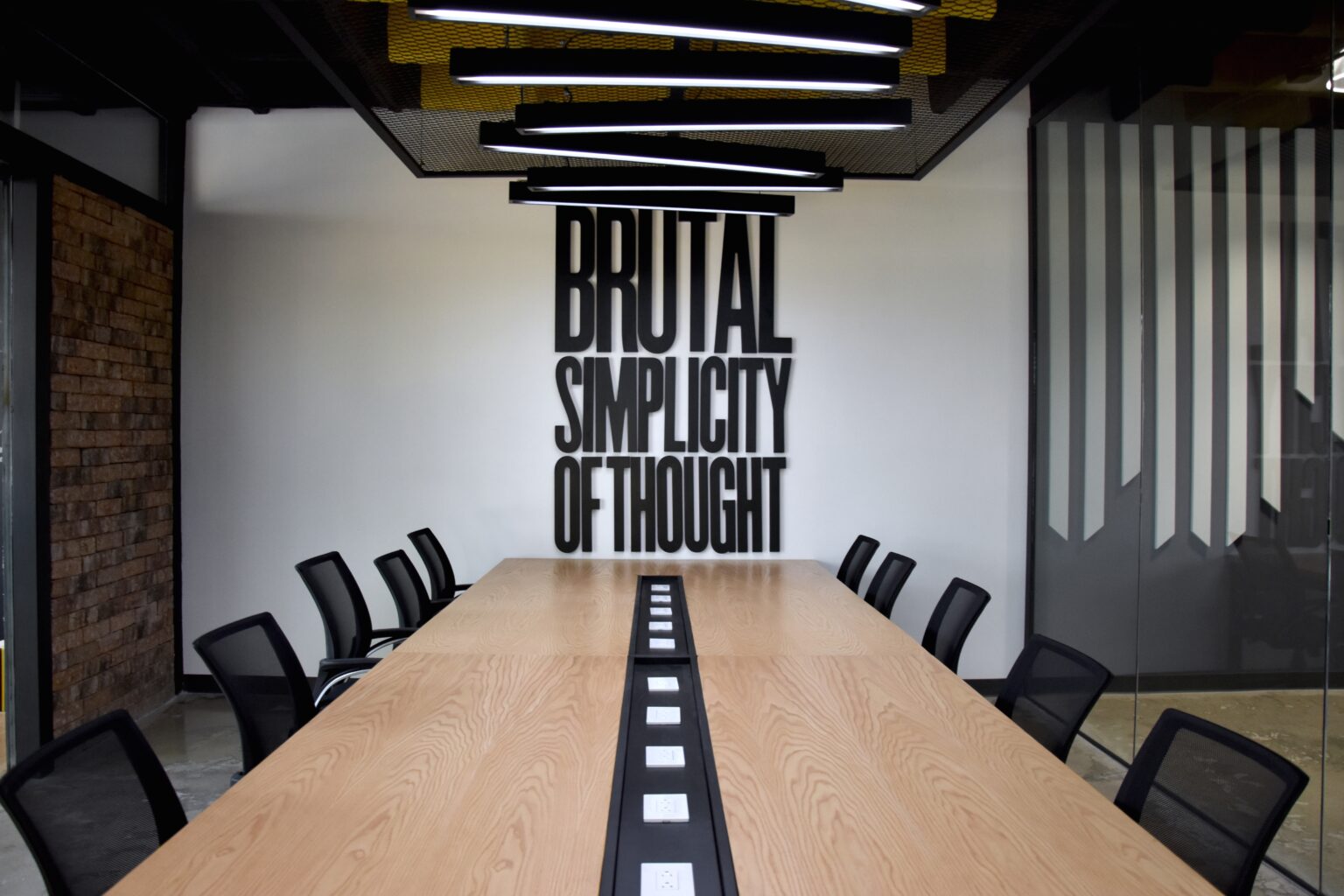 Mesa de juntas de madera con contactos integrados y luminarias lineales en M&C Saatchi