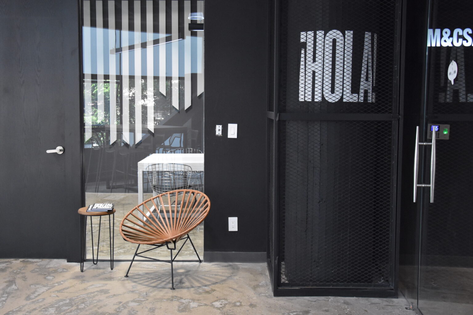 Acceso interior con silla de fibras, gabinete metálico y gráfica HOLA en M&C Saatchi