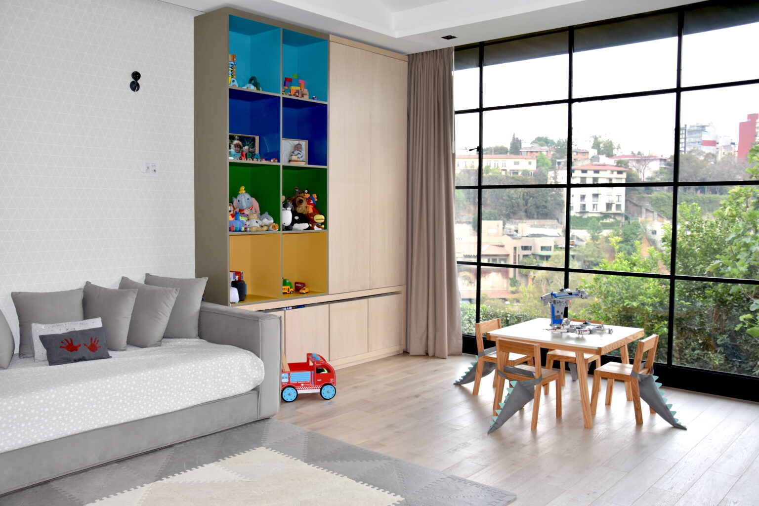 Área de juegos con sofá, mesa infantil y almacenamiento de colores
