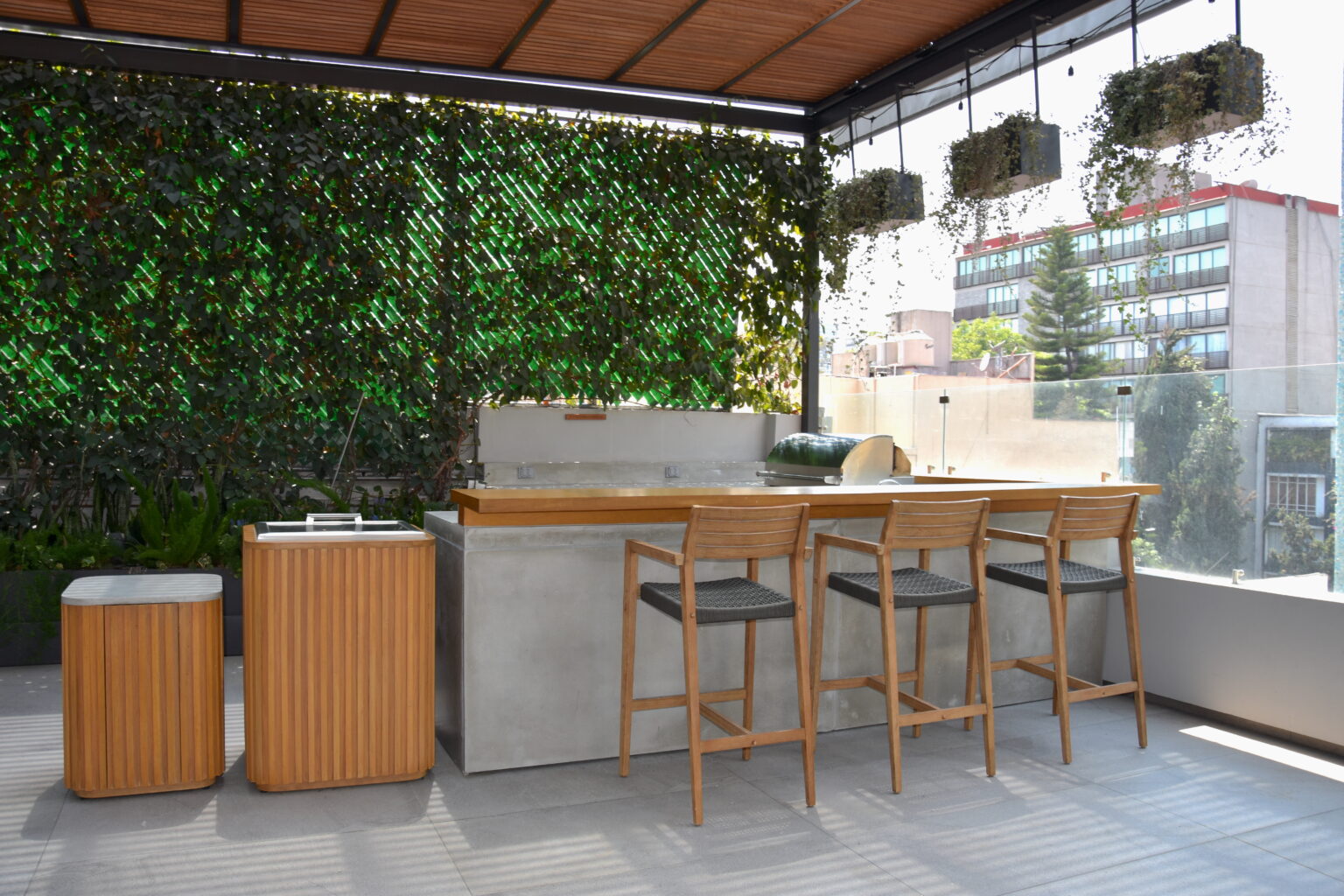 Barra exterior de concreto y madera con jardín vertical en Roof Taine