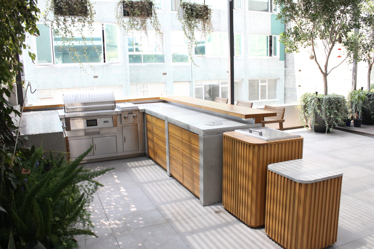 Cocina exterior de acero, concreto y madera en la terraza Roof Taine