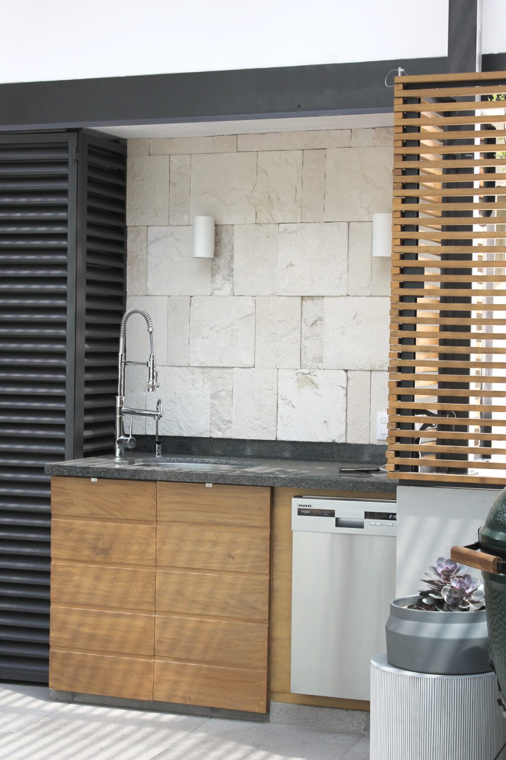 Tarja con gabinete de madera y muro de piedra en Roof Taine