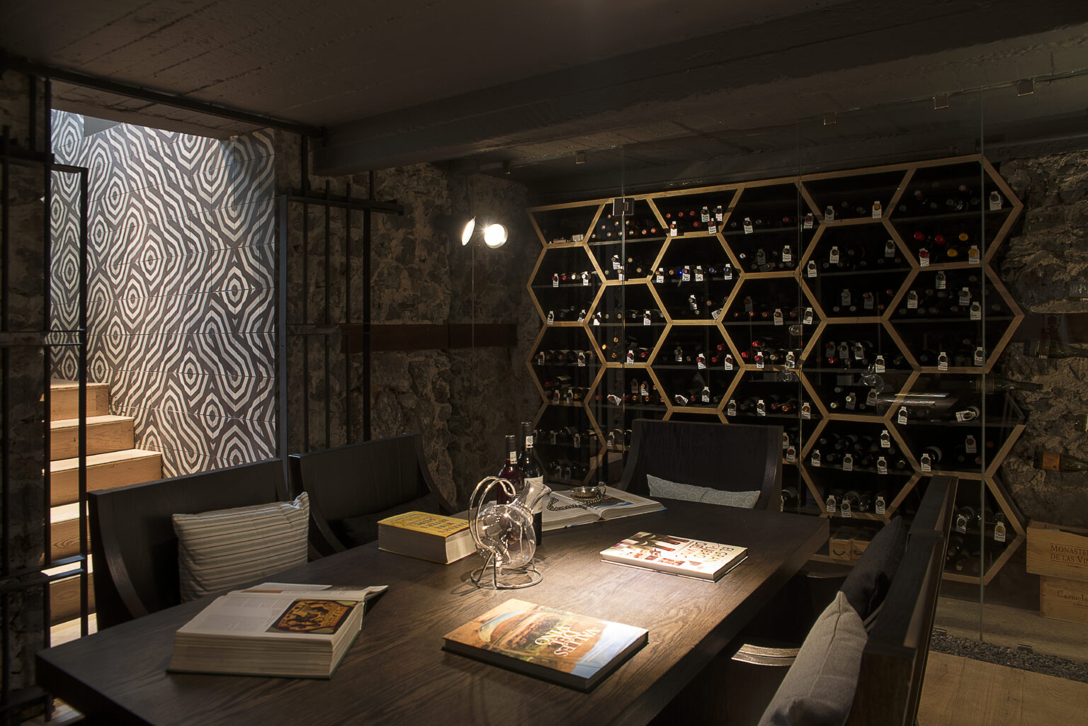 Cava de Bresca con exhibidor hexagonal de botellas y mesa central de madera