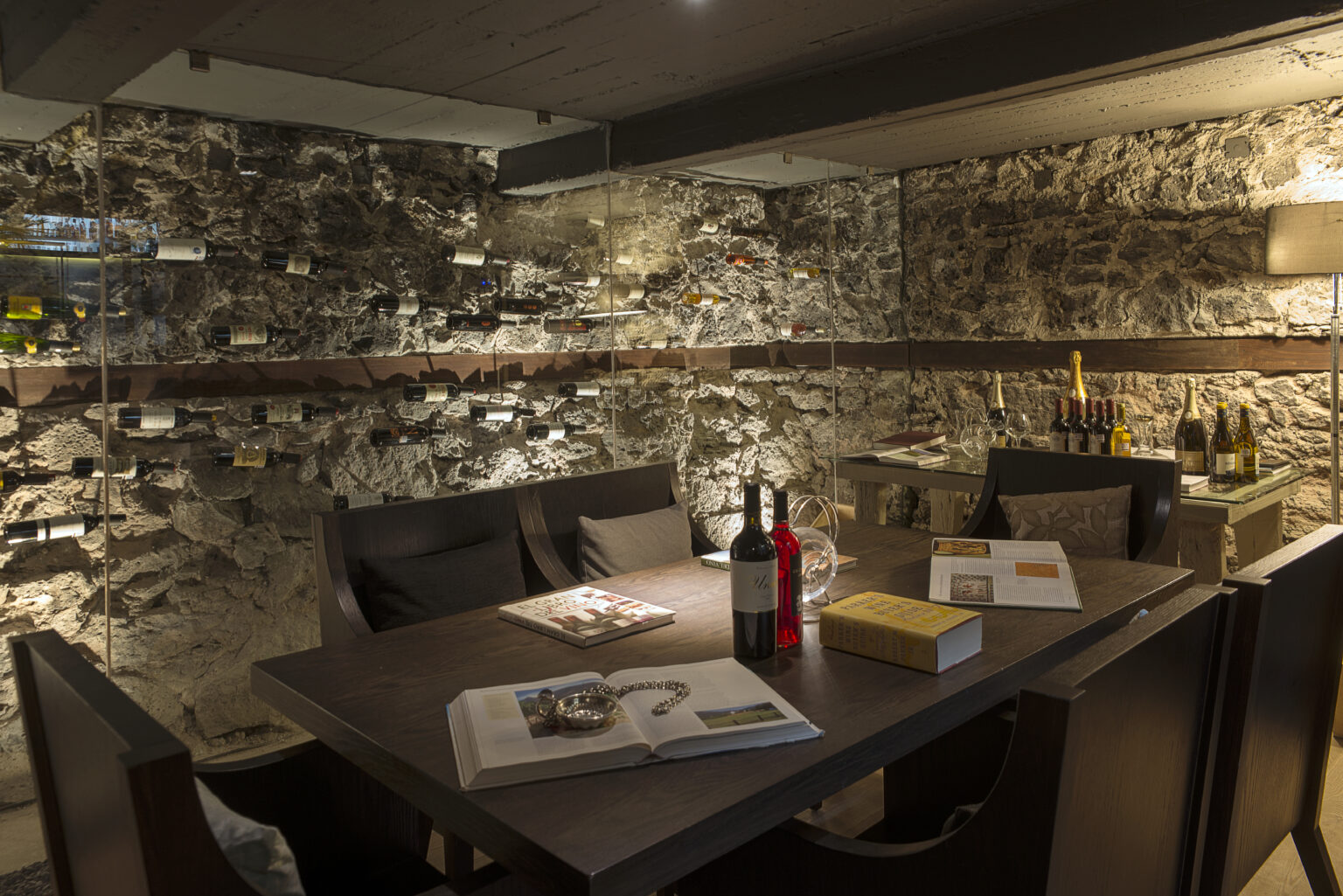 Sala de degustación de Bresca con muro de piedra, botellas y mesa de madera