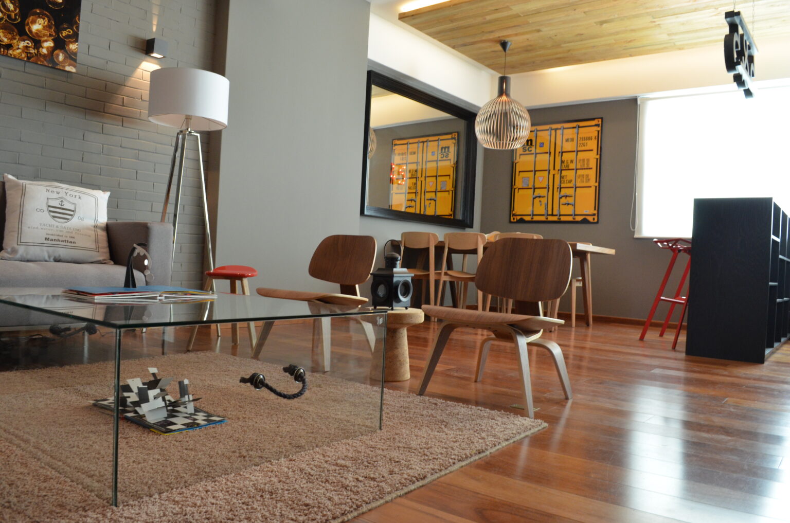 Sala con sillones de madera, mesa de cristal y comedor integrado en Vasco de Quiroga