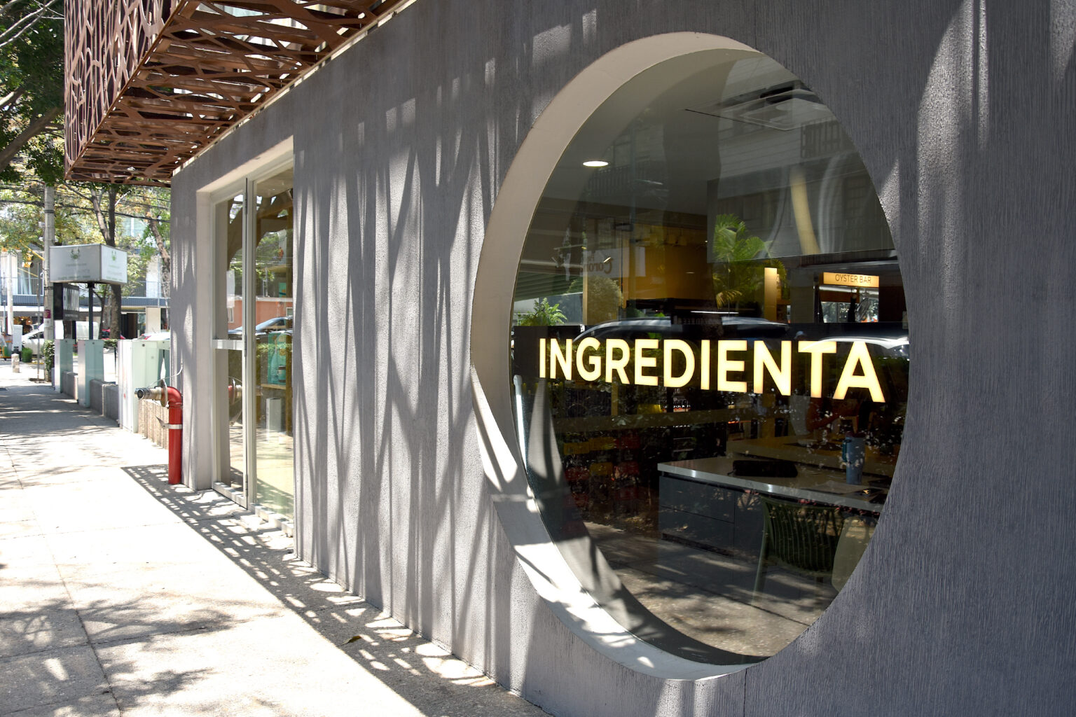 Fachada de Ingredienta Polanco con ventana circular y logotipo